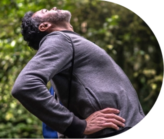 Homem experimentando dor nas costas e se alongando no parque